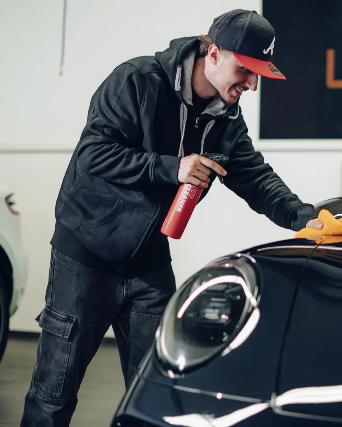 Mitarbeiter von Clean Car Zug bei der Nachbehandlung eines schwarzen Porsche 911