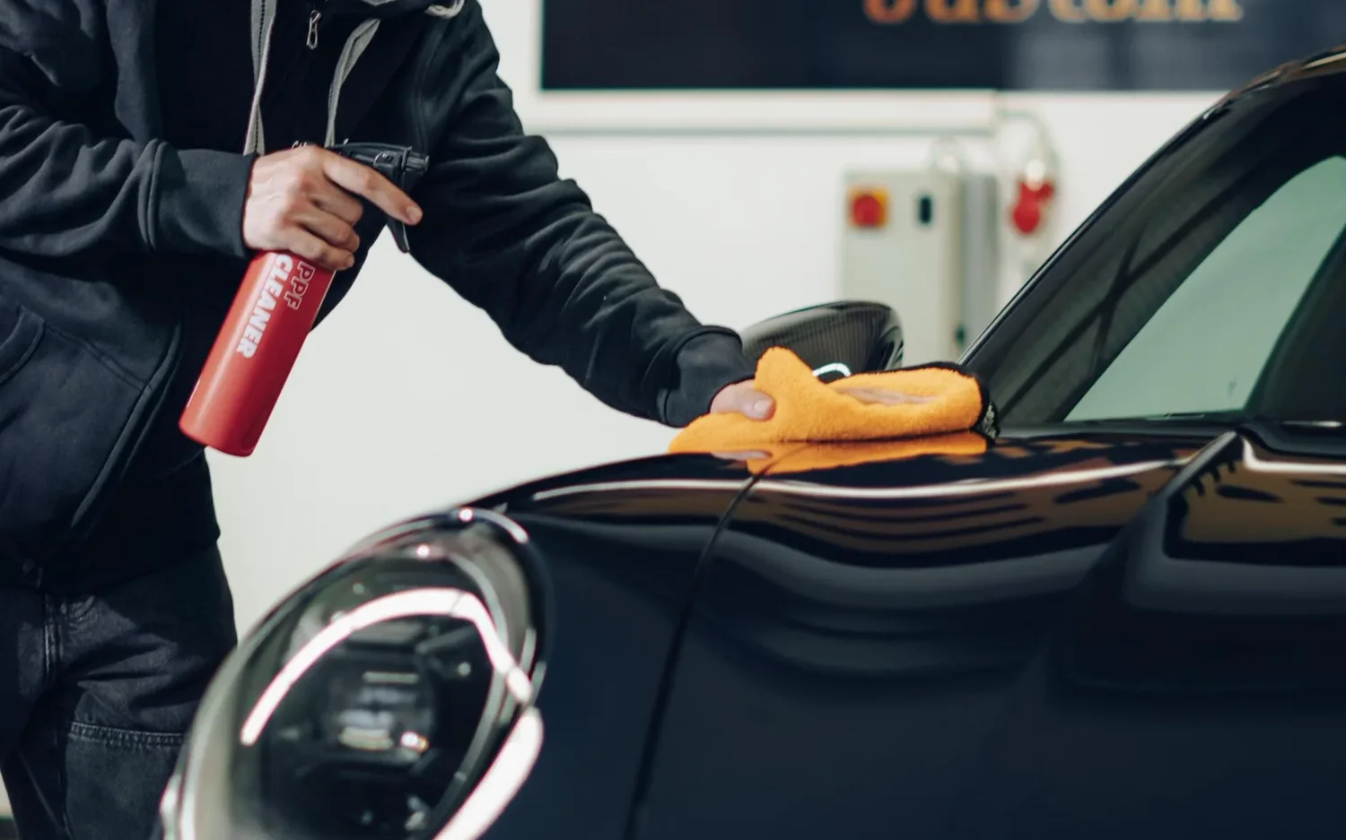 Mikrofasertuch auf der Motorhaube eines schwarzen Porsche 911
