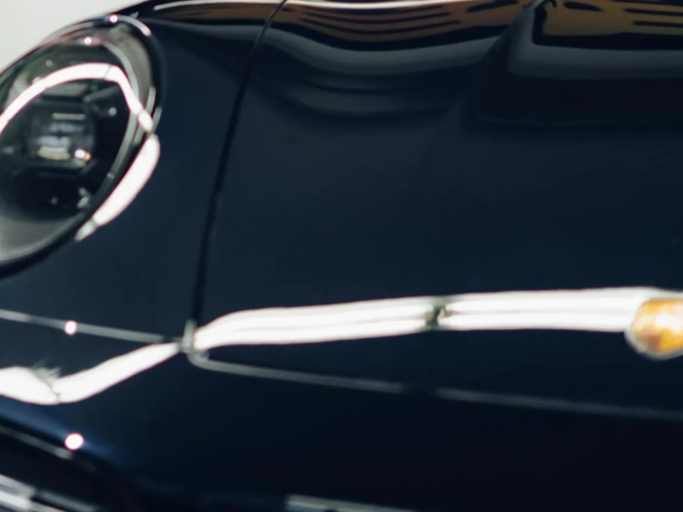 Gerichtete Reflexion auf der polierten Haube eines schwarzen Porsche 911